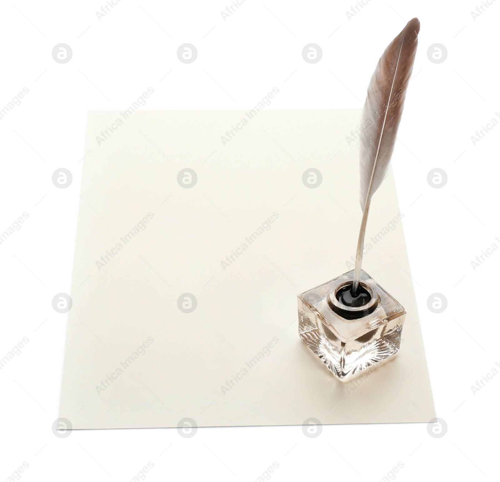 Photo of Feather pen with inkwell and blank paper on white background. Space for text