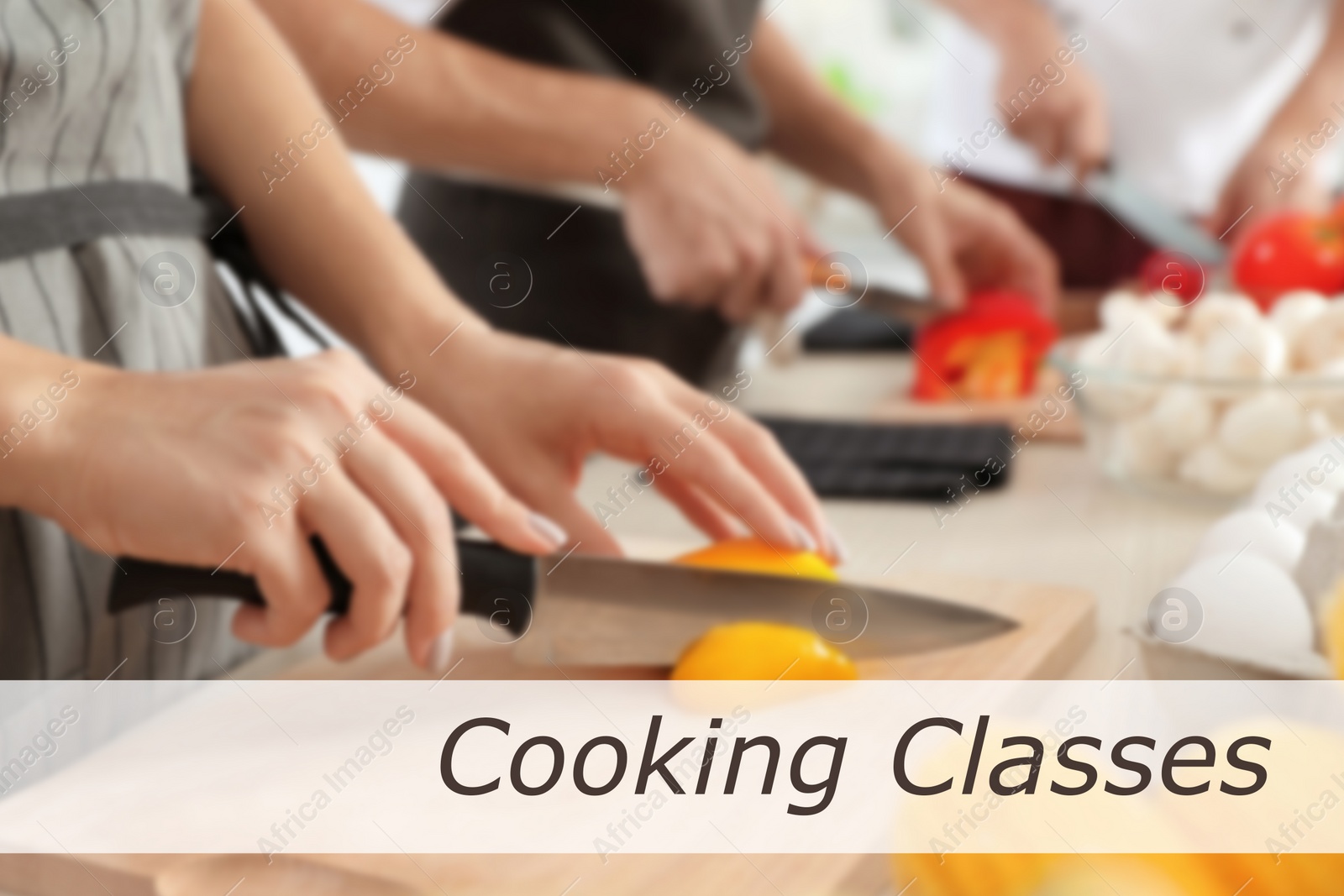 Image of Cooking classes. Blurred view of woman cutting paprika on wooden board at table, closeup