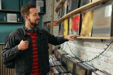 Young man choosing vinyl records in store