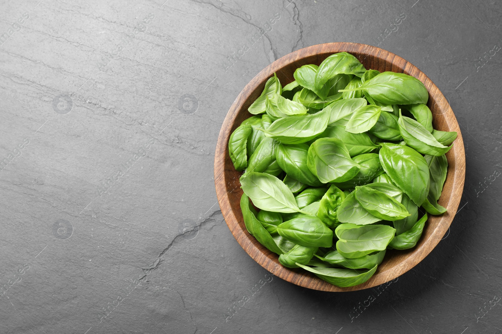 Photo of Fresh basil on grey table, top view. Space for text