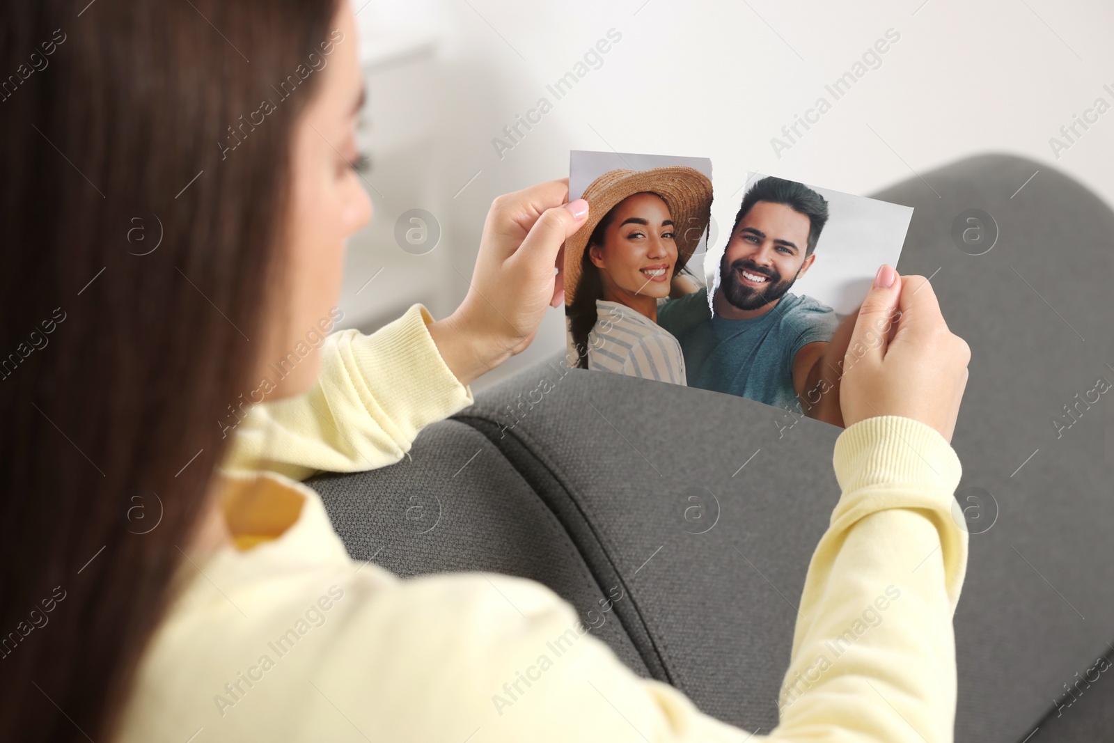 Photo of Woman ripping photo at home, closeup. Divorce concept