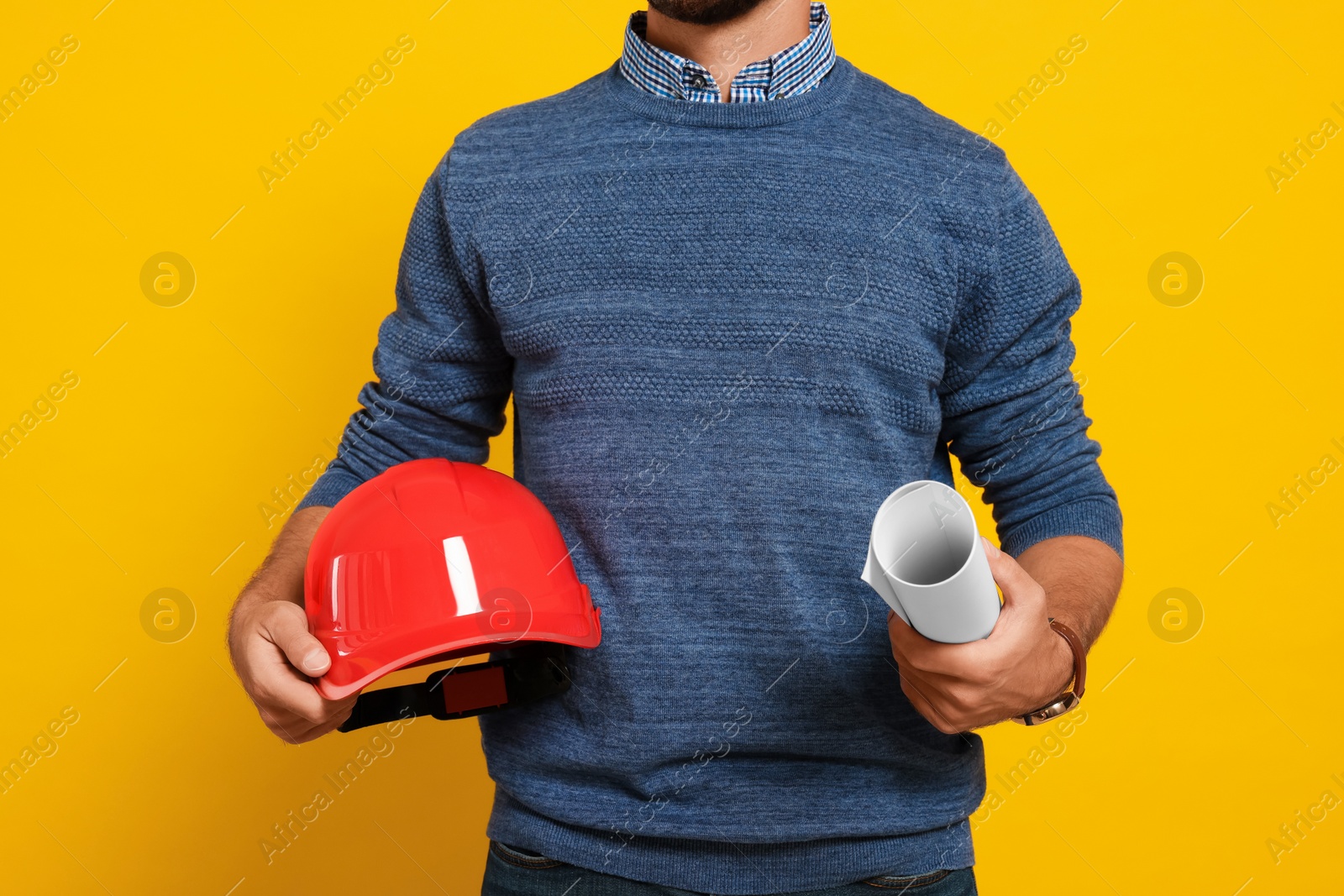 Photo of Professional engineer with hard hat and draft on yellow background, closeup