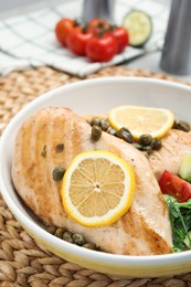 Photo of Delicious cooked chicken fillets with capers and salad on table, closeup