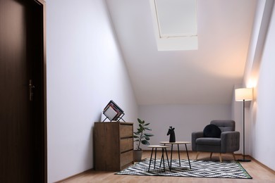 Attic room interior with slanted ceiling and furniture