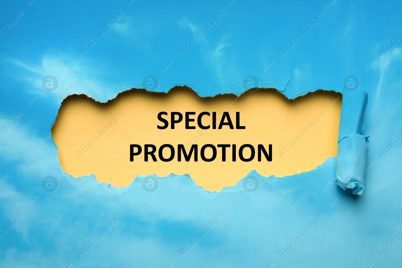 Image of Phrase Special Promotion written on yellow background, view through hole in light blue paper