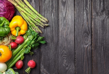 Photo of Flat lay composition with assortment of fresh vegetables on wooden table. Space for text