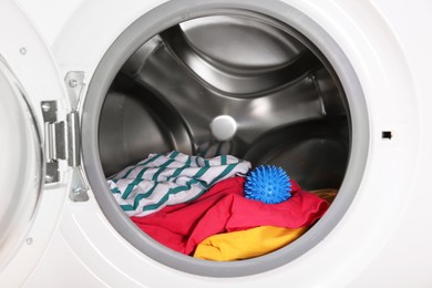 Blue dryer ball and clothes in washing machine drum