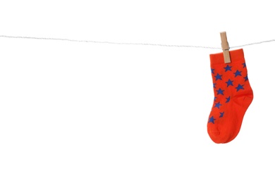 Cute child sock on laundry line against white background