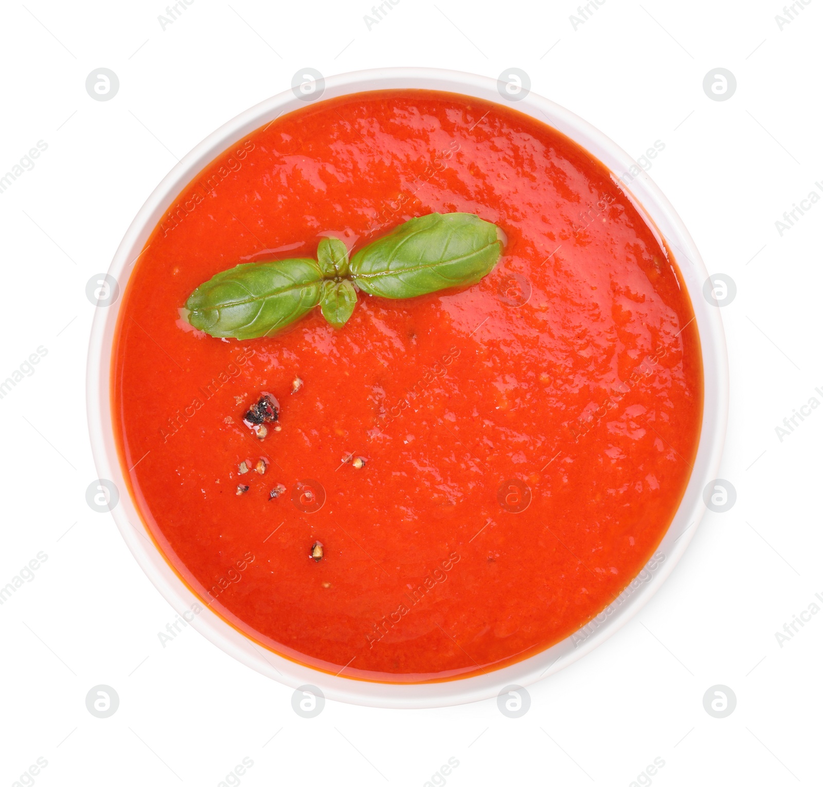 Photo of Delicious tomato cream soup in bowl isolated on white, top view