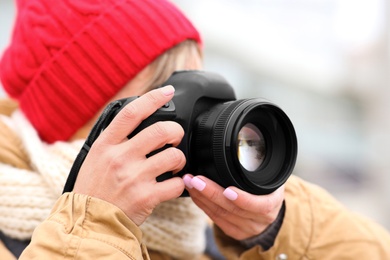 Photo of Photographer taking photo outdoors, focus on camera