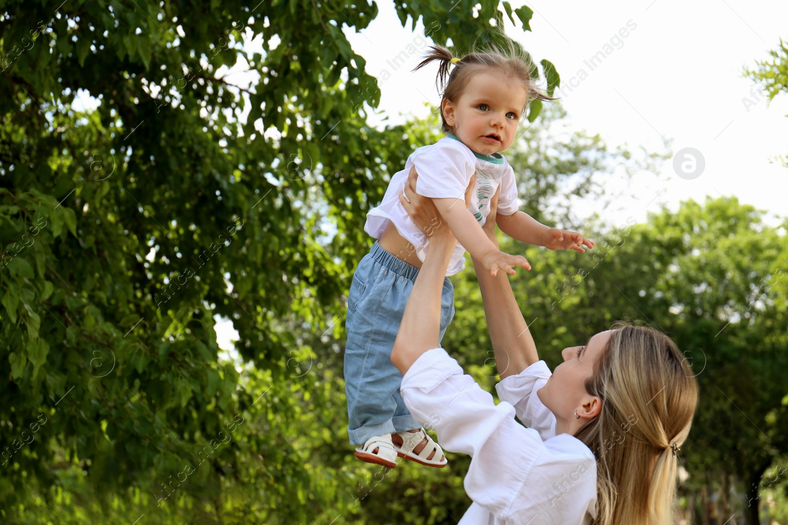 Photo of Mother with her daughter spending time together in park. Space for text