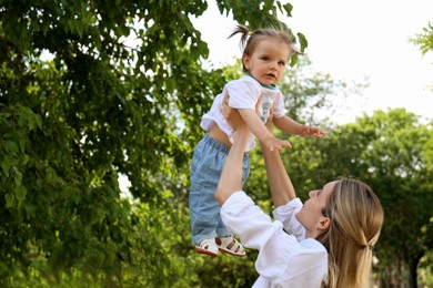 Photo of Mother with her daughter spending time together in park. Space for text