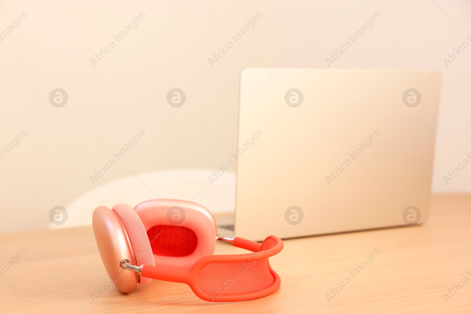 Photo of Modern headphones and laptop on wooden table. Space for text