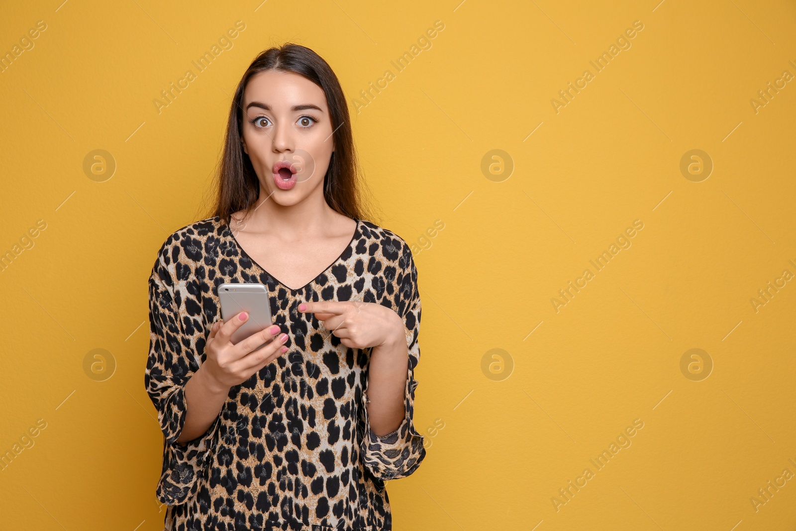 Photo of Attractive young woman using mobile phone on color background