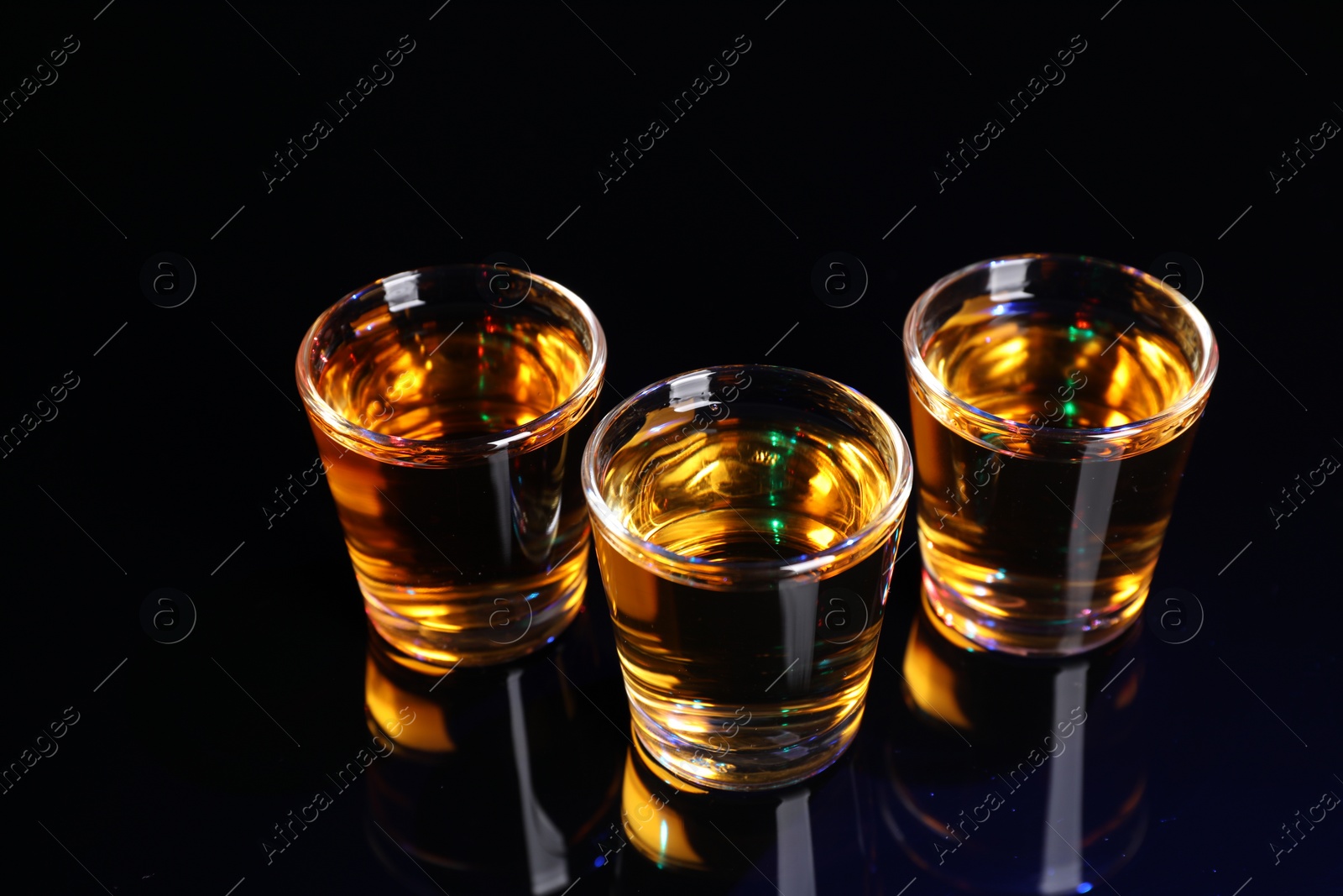 Photo of Alcohol drink in shot glasses on mirror surface