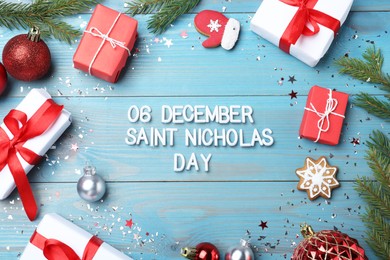 Photo of Text 6 December Saint Nicholas Day and festive decor on turquoise wooden table, flat lay