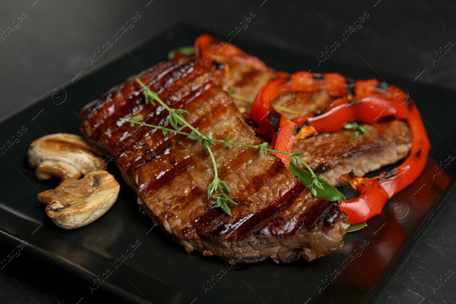 Photo of Grilled meat served with garnish on plate, closeup