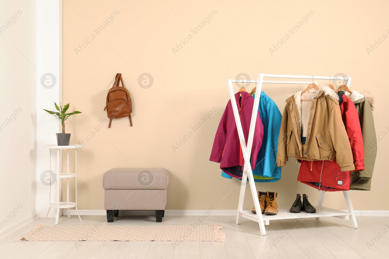 Photo of Stylish hallway interior with clothes on hanger stand