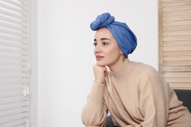 Cancer patient. Young woman with headscarf near window indoors, space for text