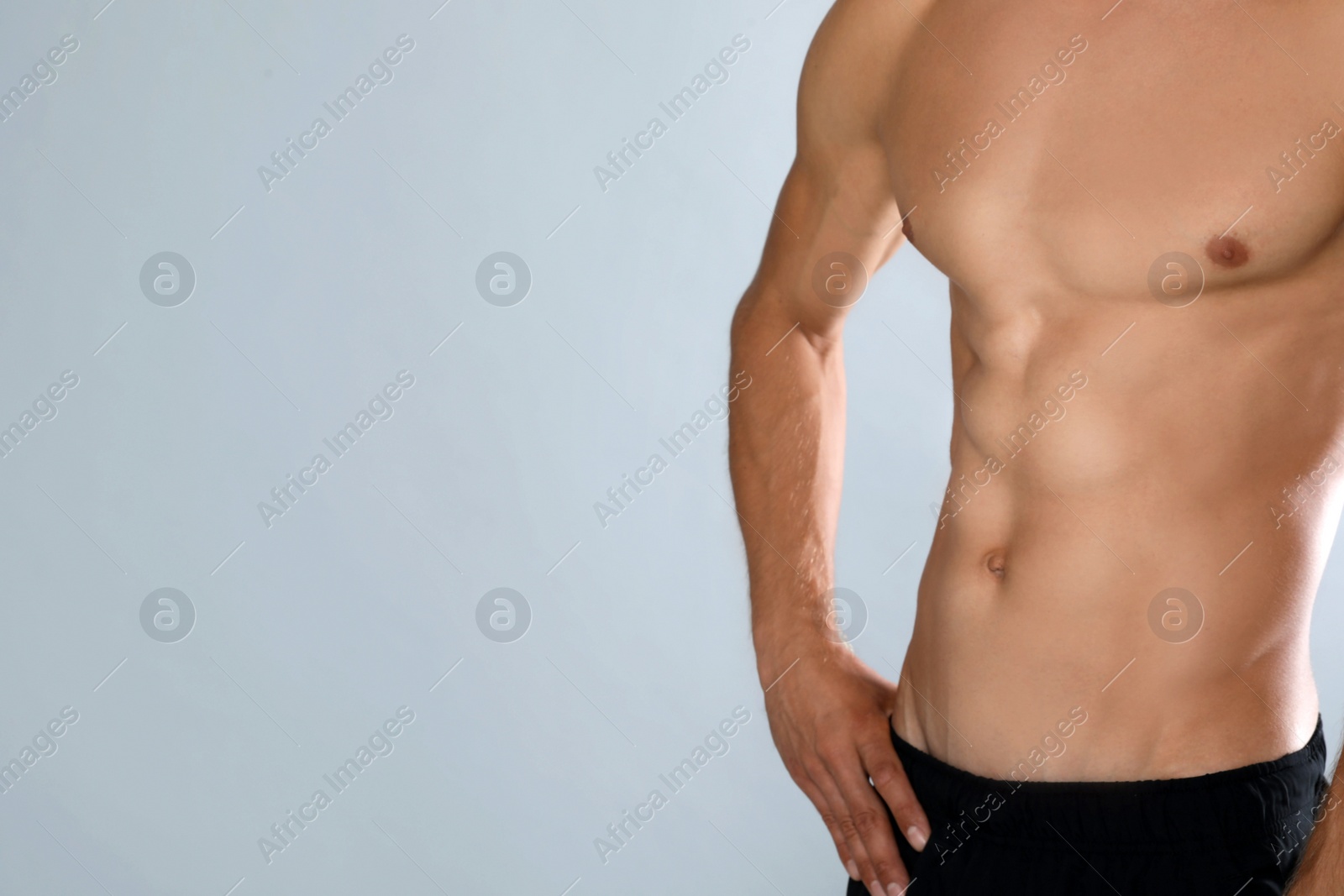 Photo of Shirtless man with slim body on grey background, closeup. Space for text