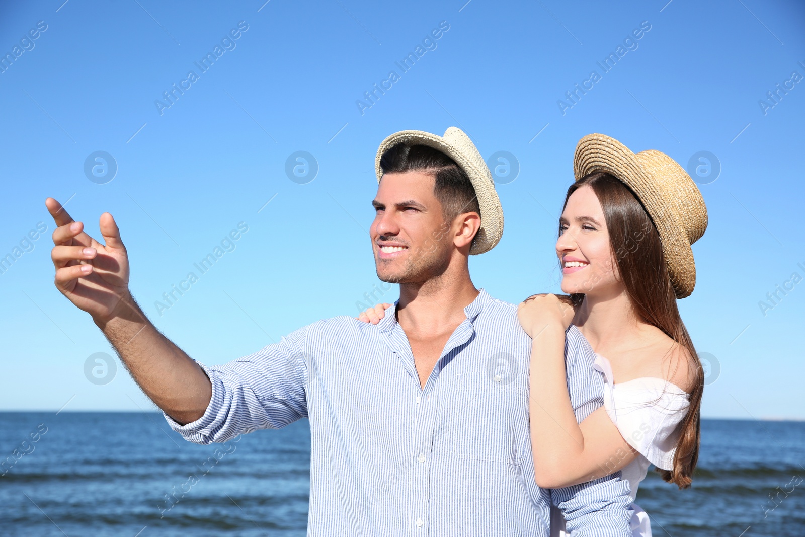 Photo of Lovely couple wearing hats together on beach