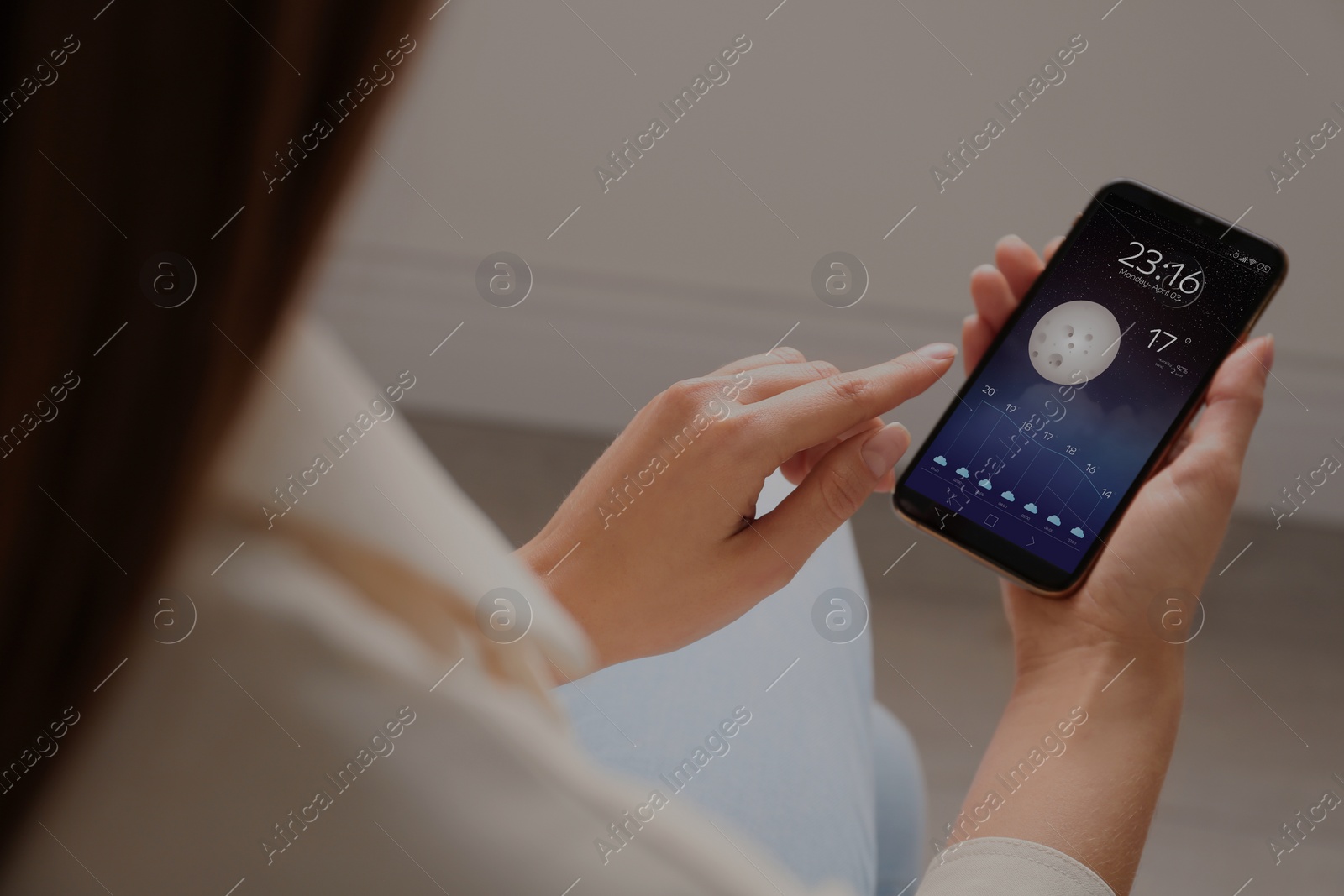 Image of Woman using weather forecast app on smartphone indoors, closeup