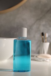 Photo of Bottle of mouthwash on light countertop in bathroom