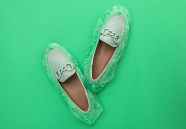 Photo of Women's mules in shoe covers on green background, top view