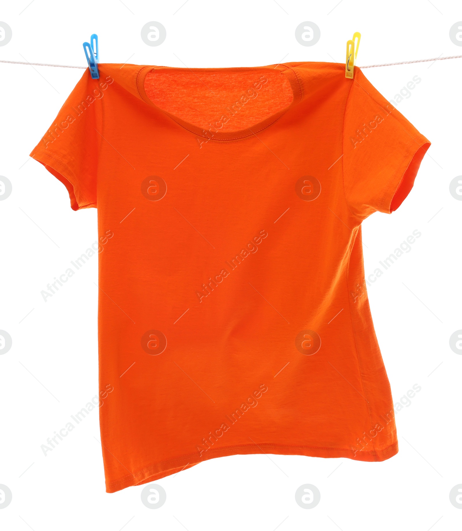 Photo of One orange t-shirt drying on washing line isolated on white