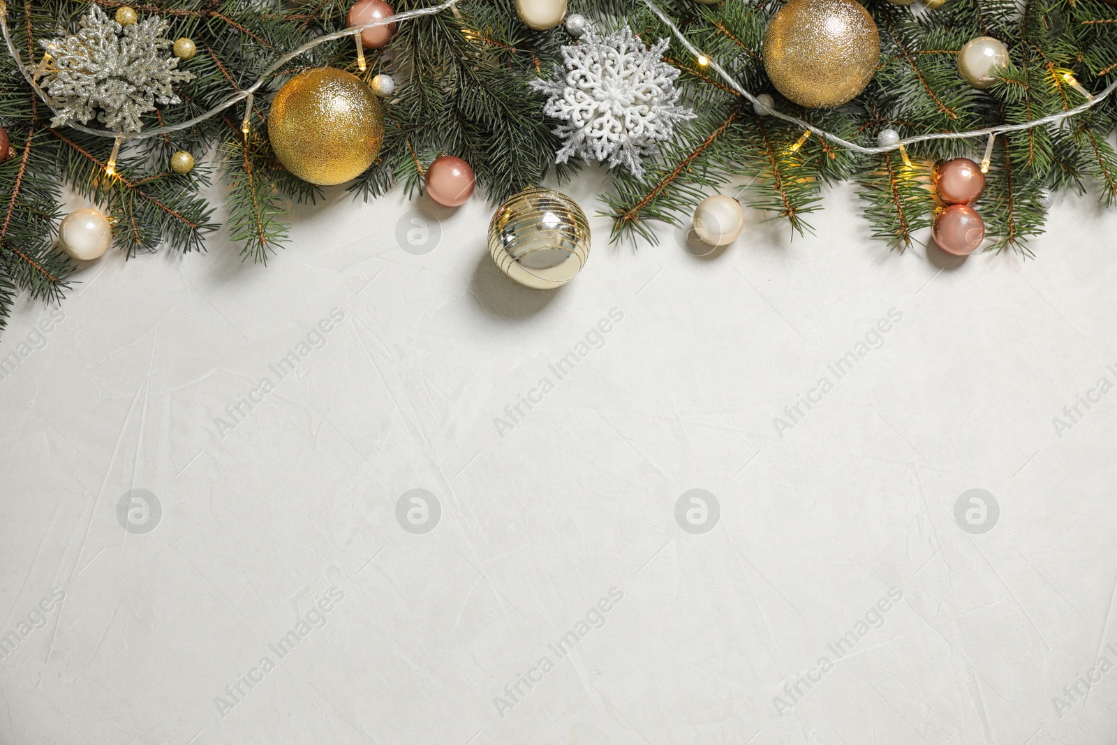 Photo of Christmas decoration on white stone background, flat lay. Space for text