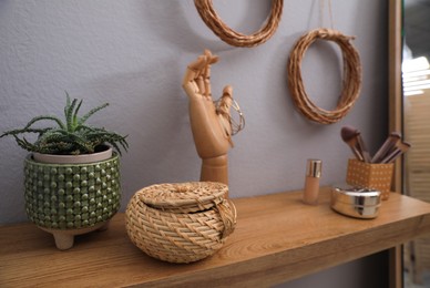 Photo of Cosmetics, accessories, plant and decor on wooden table