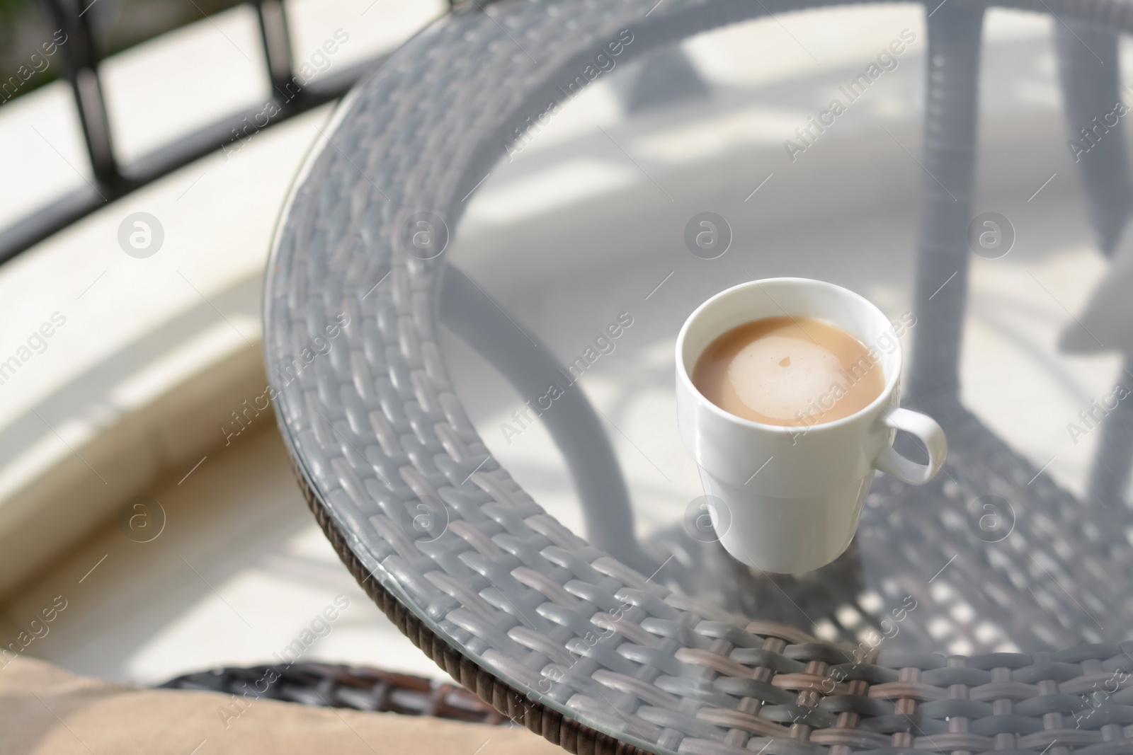 Photo of Ceramic cup of aromatic coffee on glass table outdoors. Good morning