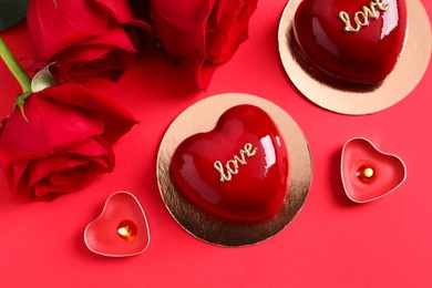 Photo of St. Valentine's Day. Delicious heart shaped cakes and roses on red background, flat lay