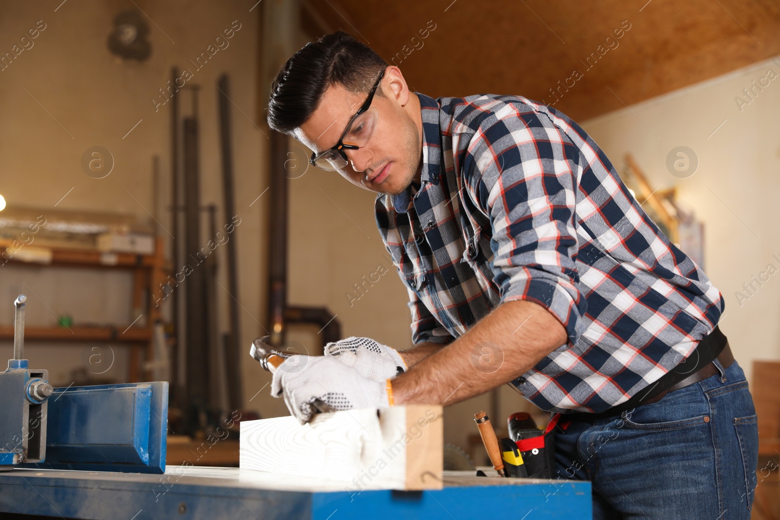 Photo of Professional carpenter working with wooden plank in workshop