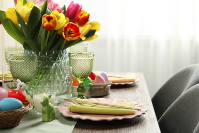 Photo of Easter celebration. Festive table setting with beautiful flowers and painted eggs