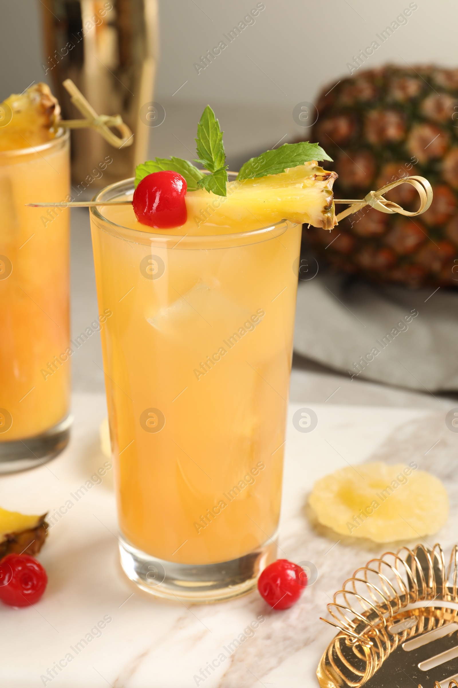 Photo of Tasty pineapple cocktail with mint and cherry on table