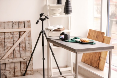Photo of Professional camera and food composition on table in photo studio