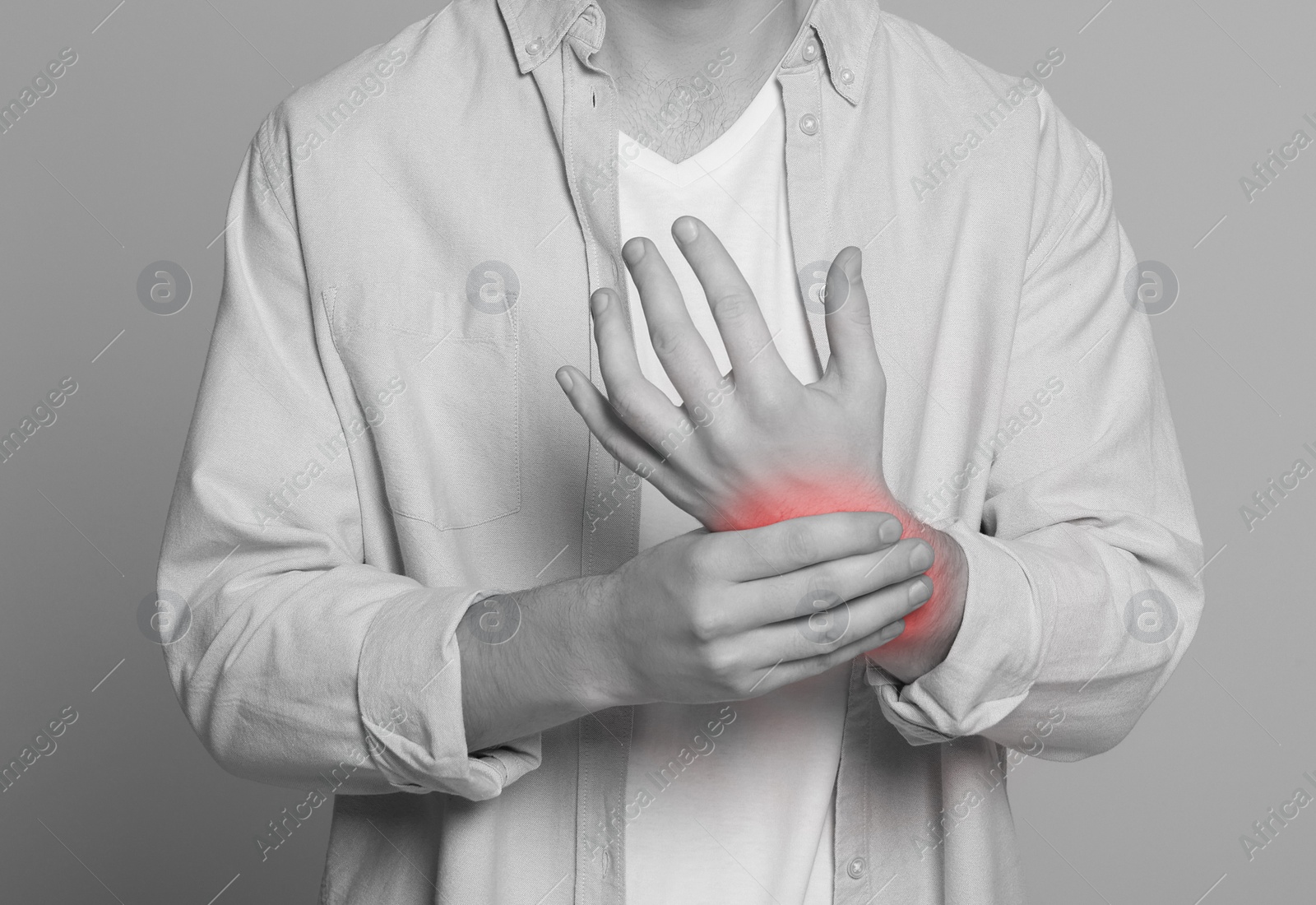 Image of Man suffering from pain in wrist, closeup. Black and white effect