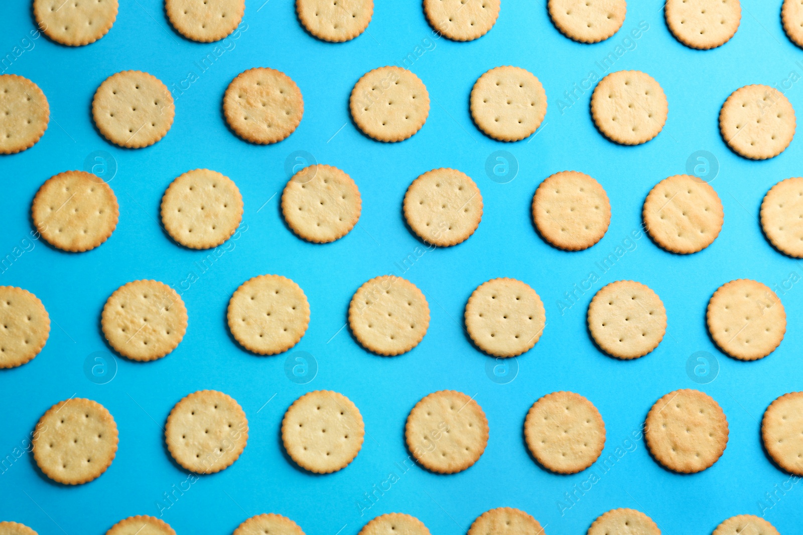 Photo of Delicious crackers on light blue background, flat lay