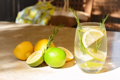 Photo of Tasty refreshing lemonade and ingredients on light table, space for text. Summer drink