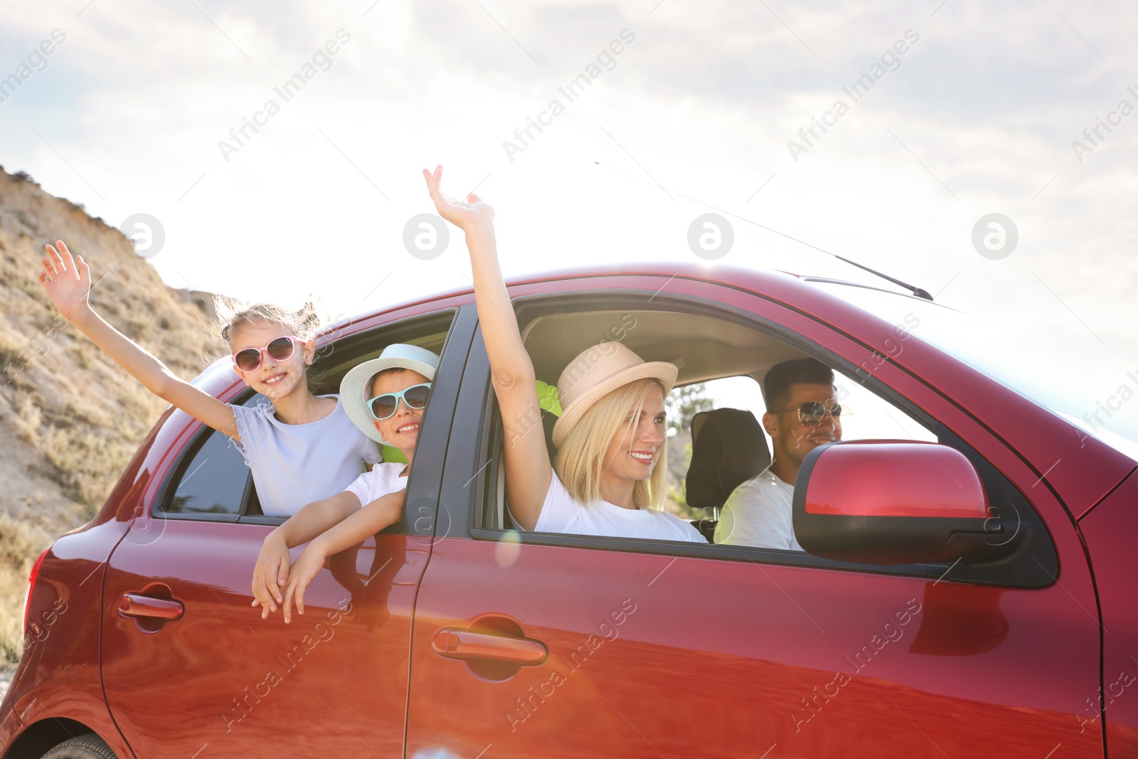 Photo of Happy family in car at beach on sunny day