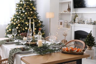 Christmas table setting with festive decor and dishware in living room interior