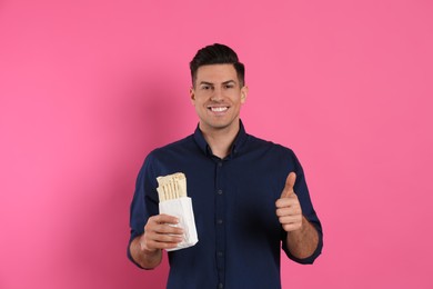 Photo of Man with delicious shawarma on pink background