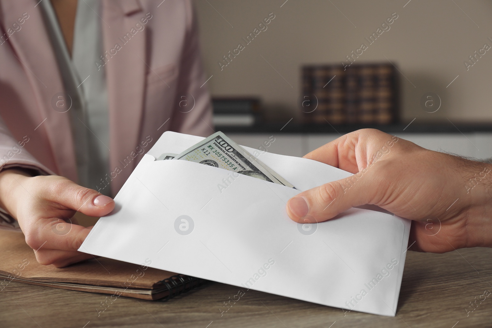 Photo of Man giving bribe to woman at table, closeup