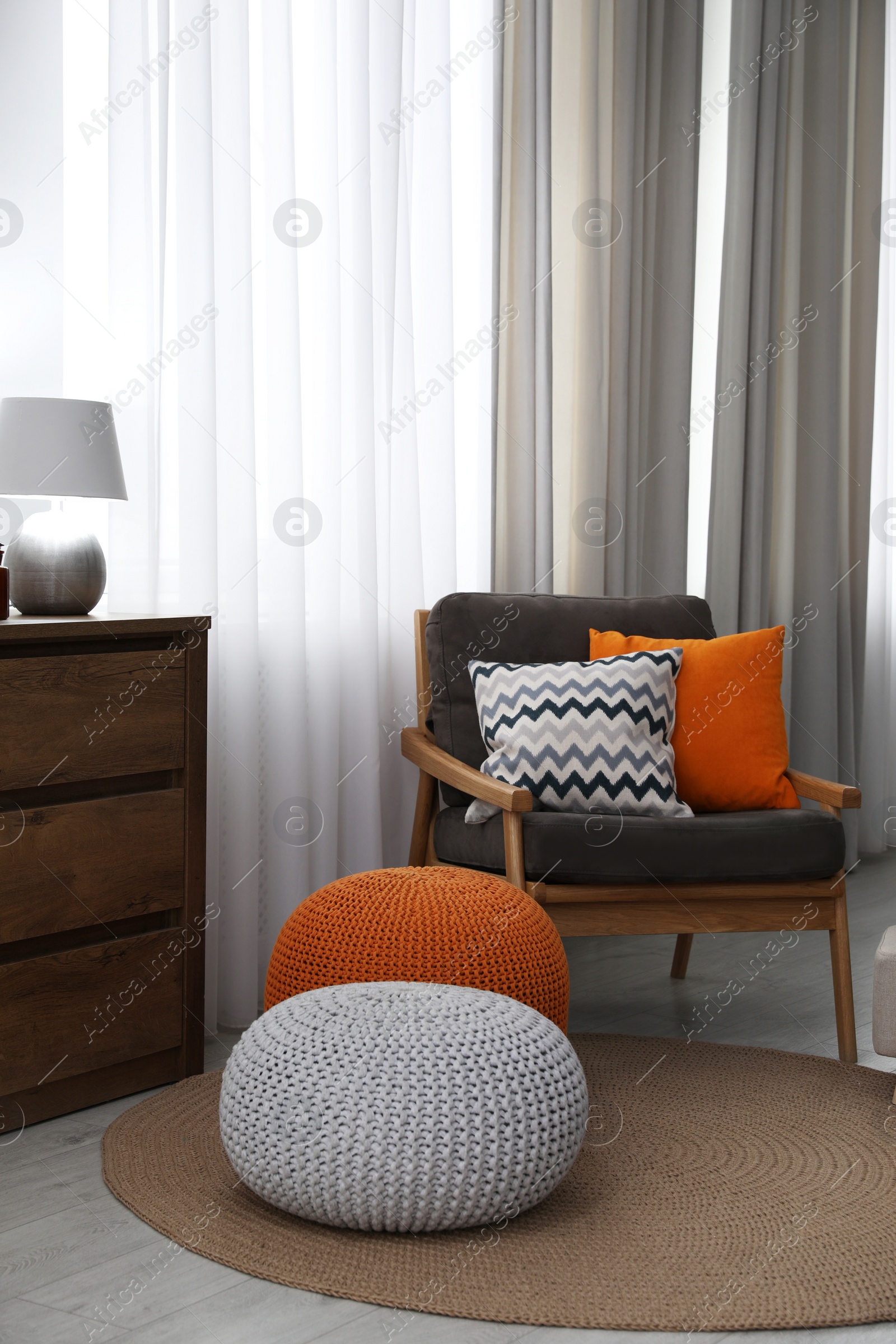 Photo of Stylish comfortable poufs near armchair in room. Home design