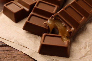 Photo of Tasty chocolate bars on wooden table, closeup