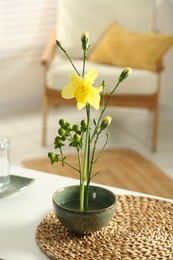 Stylish ikebana with beautiful yellow narcissus flower carrying cozy atmosphere at home