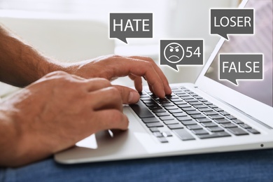 Image of Man using laptop and icons with offensive messages, closeup. Cyber bulling concept
