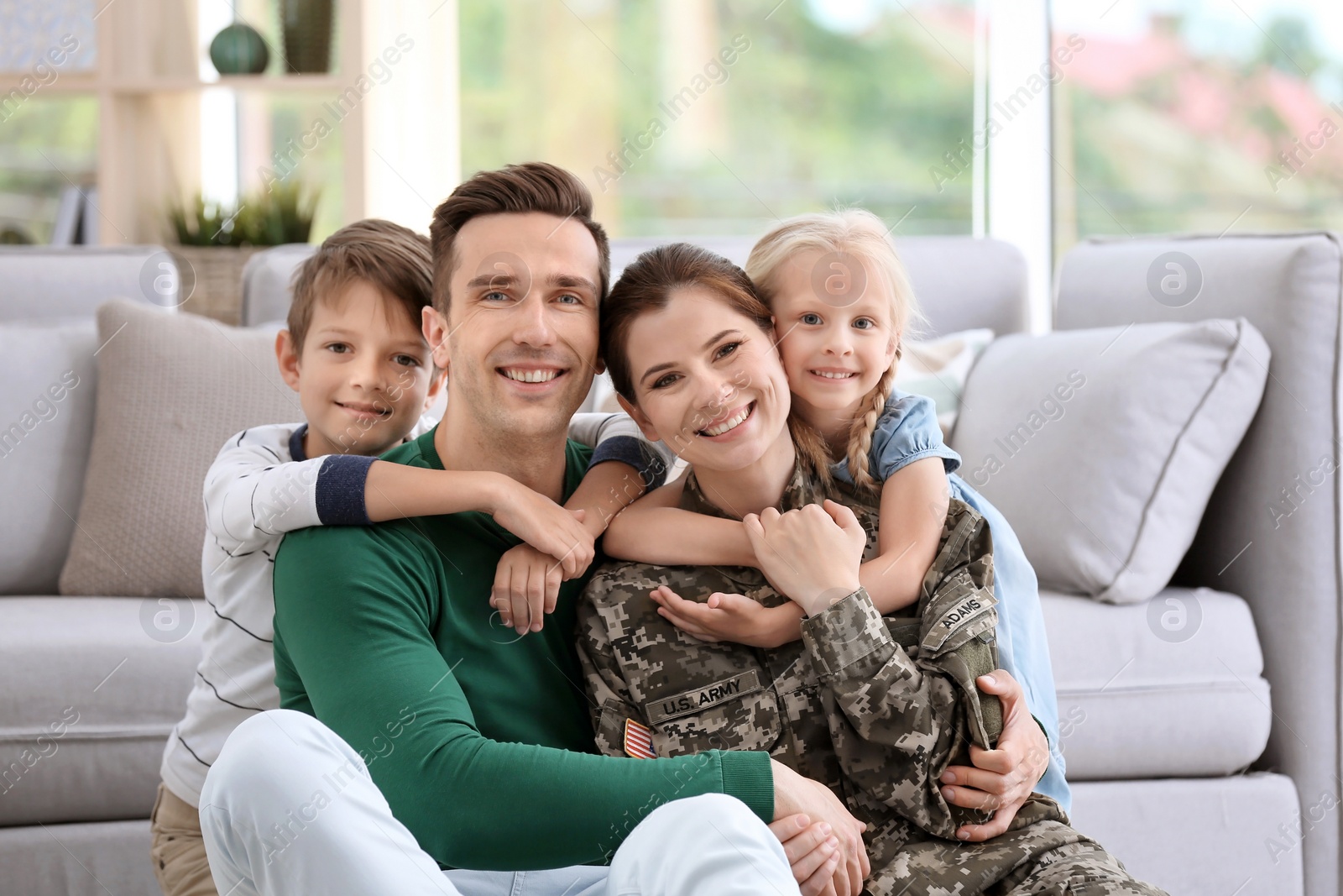 Photo of Woman in military uniform with her family at home