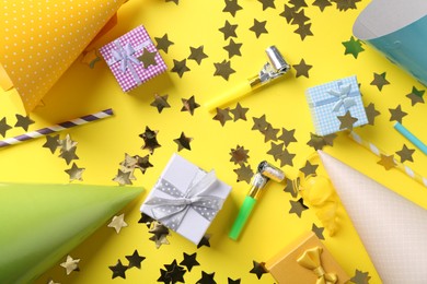 Photo of Flat lay composition with party hats on yellow background